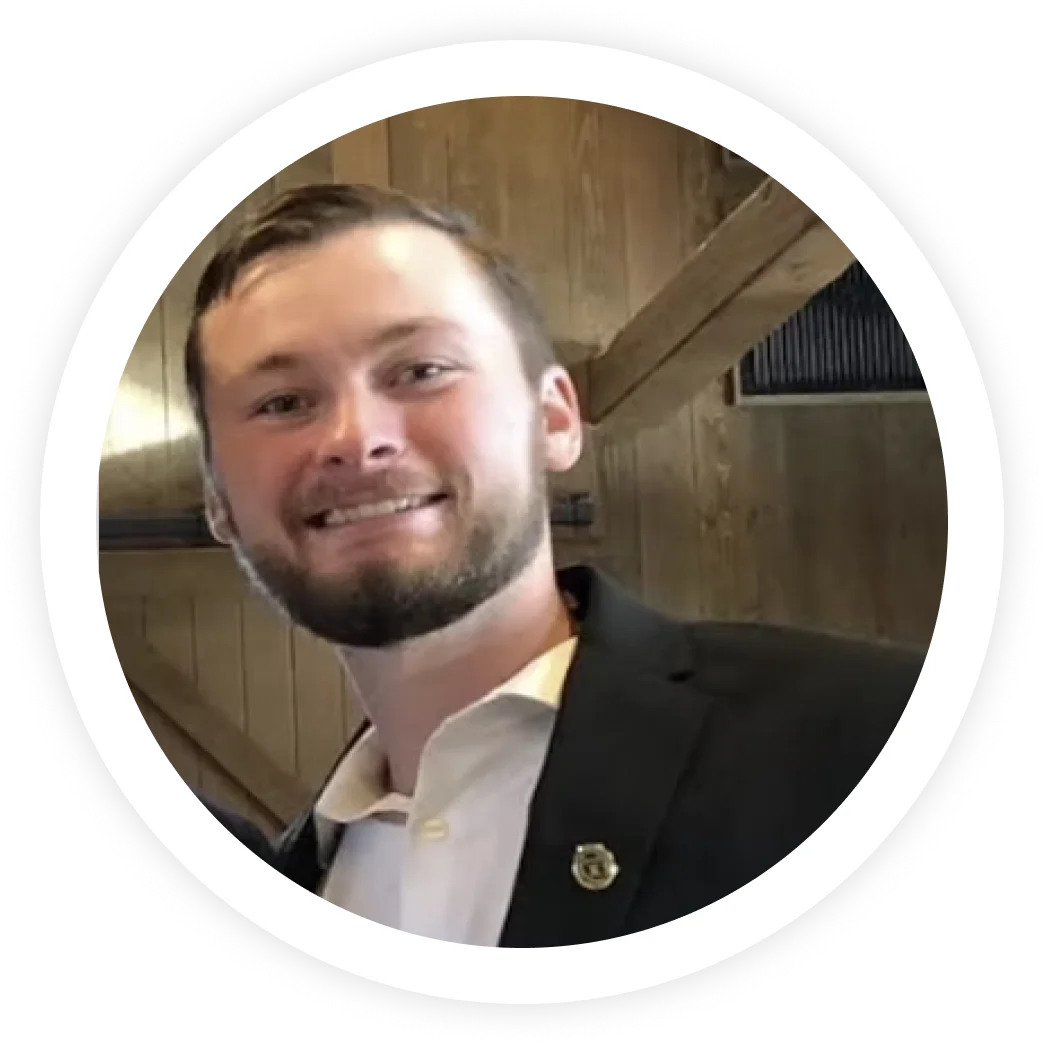 Professional headshot of man in suit smiling indoors