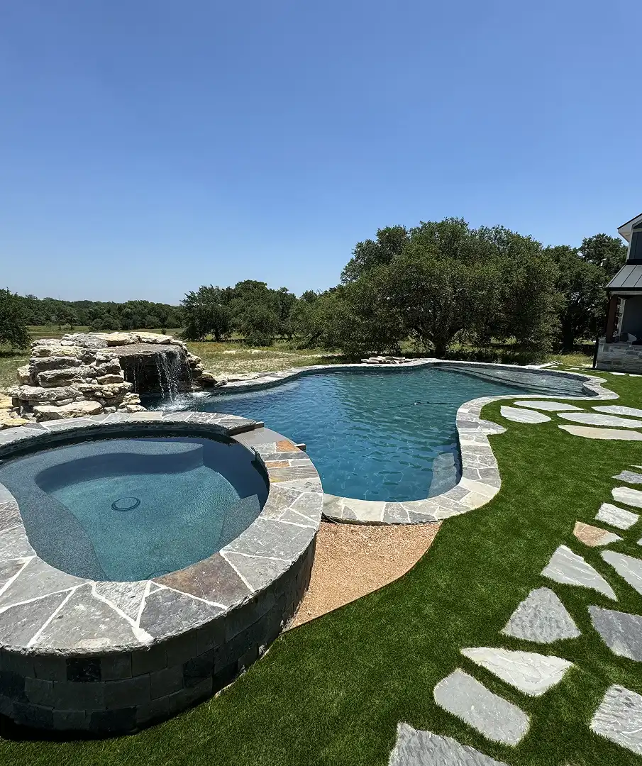 Pool with waterfall feature and spa in Bee Cave.