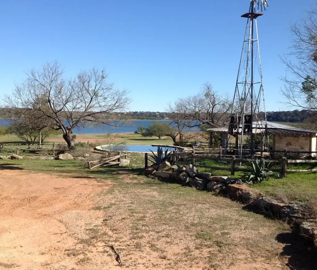 Cistern pool nestled between a lake and a windmill in Texas.